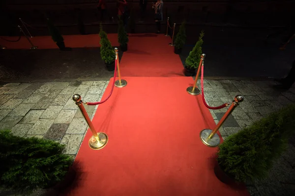 Alfombra roja se utiliza tradicionalmente para marcar la ruta tomada por los jefes de Estado en ocasiones ceremoniales y formales, y en las últimas décadas se ha ampliado a su uso por los VIP y celebridades en eventos formales . — Foto de Stock