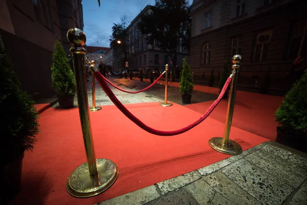 Alfombra roja se utiliza tradicionalmente para marcar la ruta tomada por los jefes de Estado en ocasiones ceremoniales y formales, y en las últimas décadas se ha ampliado a su uso por los VIP y celebridades en eventos formales . — Foto de Stock