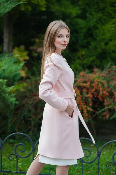 Belle jeune femme blonde portant un manteau rose — Photo