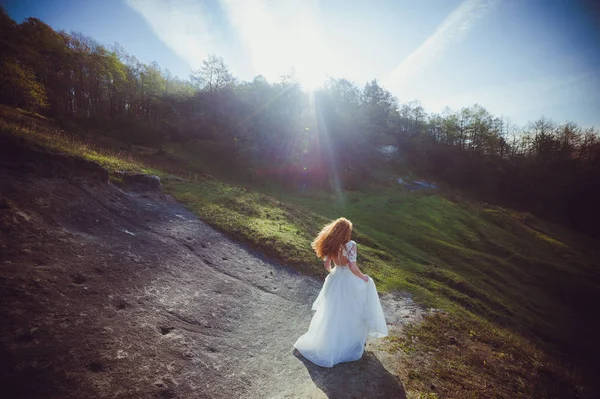 森の中に花束を持った白いドレスを着た美しい若い女性 — ストック写真