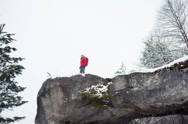 Dağlarda kış yürüyüşü. Sıcak, modern turist kıyafetleri. Yürüyüşe çıkmış bir kadın.