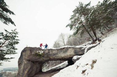 Dağlarda kış yürüyüşü. Sıcak, modern turist kıyafetleri. Kadın ve erkek yürüyüşe çıktılar.