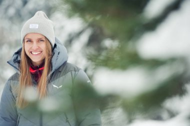 Dağlarda kış yürüyüşü. Sıcak, modern turist kıyafetleri. Yürüyüşe çıkmış bir kadın.