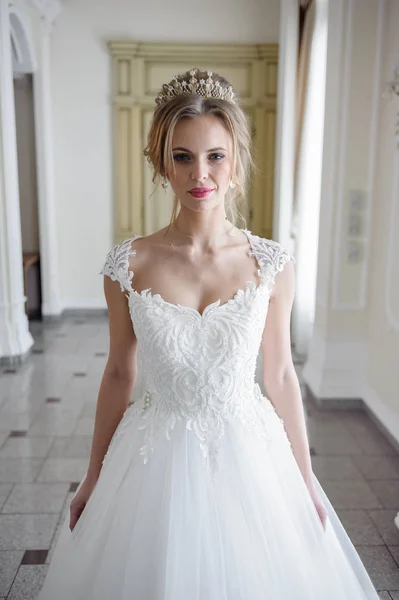 大きなシャンデリアと豪華な白い部屋でウェディング ドレスの美しい花嫁 — ストック写真