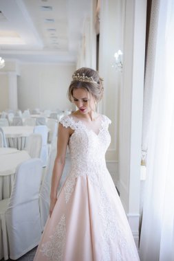 Pencere kenarında gelinlik içinde güzel bir gelin portresi.