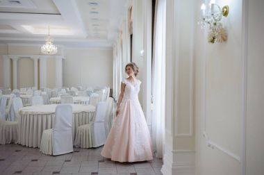 Pencere kenarında gelinlik içinde güzel bir gelin portresi.