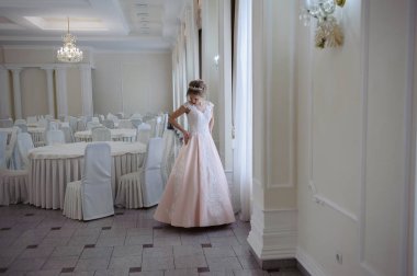 Pencere kenarında gelinlik içinde güzel bir gelin portresi.