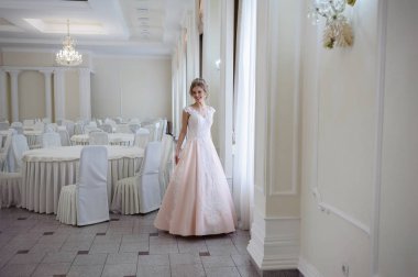 Pencere kenarında gelinlik içinde güzel bir gelin portresi.