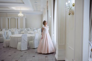 Pencere kenarında gelinlik içinde güzel bir gelin portresi.