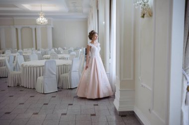 Pencere kenarında gelinlik içinde güzel bir gelin portresi.