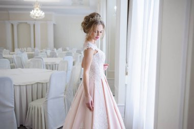 Pencere kenarında gelinlik içinde güzel bir gelin portresi.