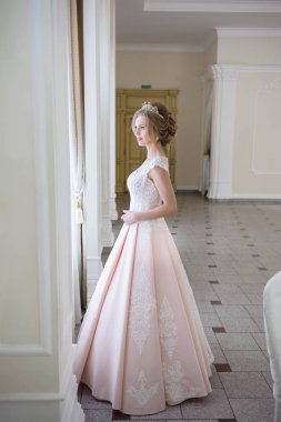 Pencere kenarında gelinlik içinde güzel bir gelin portresi.