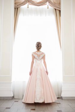 Pencere kenarında gelinlik içinde güzel bir gelin portresi.