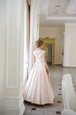 Pencere kenarında gelinlik içinde güzel bir gelin portresi.