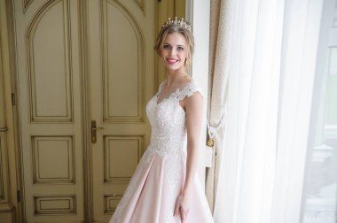 Pencere kenarında gelinlik içinde güzel bir gelin portresi.