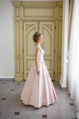 Pencere kenarında gelinlik içinde güzel bir gelin portresi.