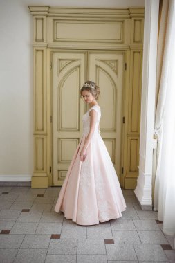 Pencere kenarında gelinlik içinde güzel bir gelin portresi.