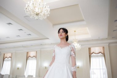 Pencere kenarında gelinlik içinde güzel bir gelin portresi.