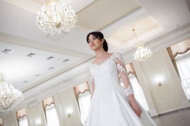 Pencere kenarında gelinlik içinde güzel bir gelin portresi.