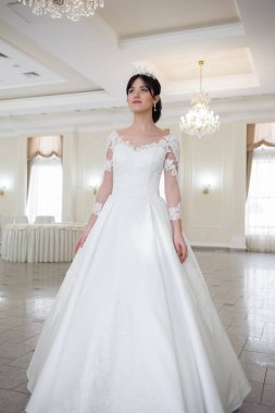 Pencere kenarında gelinlik içinde güzel bir gelin portresi.