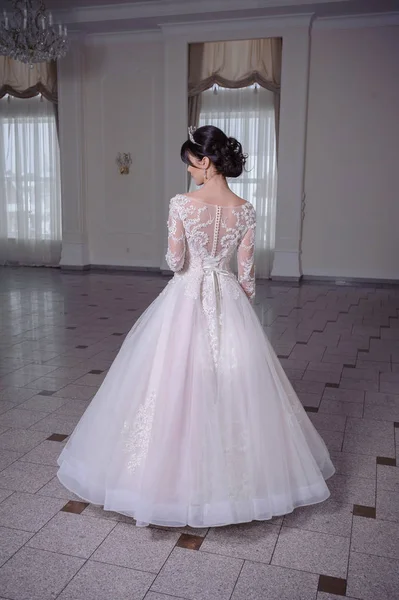 大きなシャンデリアと豪華な白い部屋でウェディング ドレスの美しい花嫁 — ストック写真