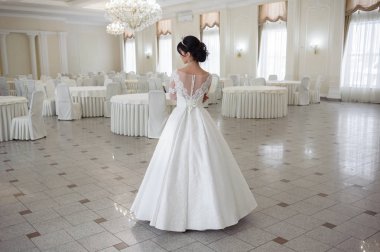 Pencere kenarında gelinlik içinde güzel bir gelin portresi.