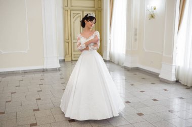 Pencere kenarında gelinlik içinde güzel bir gelin portresi.