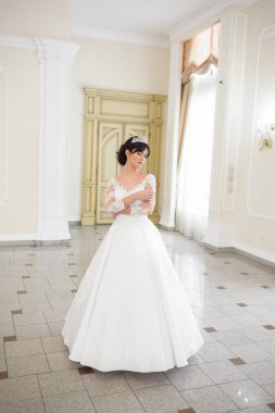 Pencere kenarında gelinlik içinde güzel bir gelin portresi.