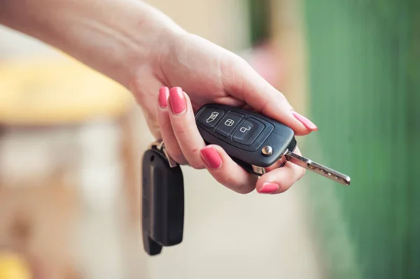 Car key in woman's hand. Seller and transport insurance.