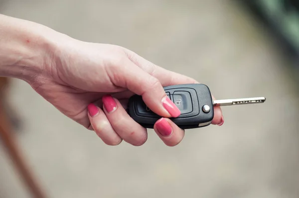 Car key in woman\'s hand. Seller and transport insurance.