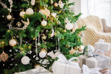 Klasik yılbaşı, yeni yıl dekore edilmiş iç mekan ağacı. Altın madalyalı Noel ağacı. Modern beyaz klasik tarz iç tasarım