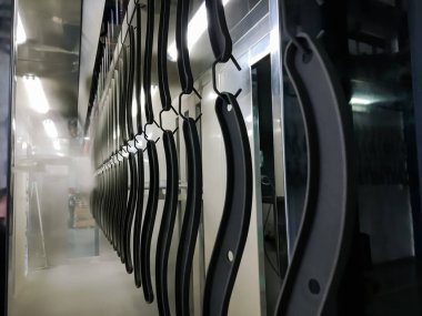 Toz kaplama hattı. Metal paneller, üstteki taşıma hattında askıya alındı. Elektrostatik alanda boyama ürünleri.