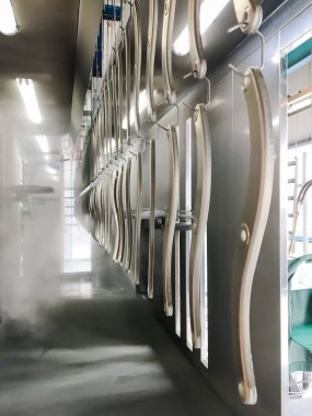 Toz kaplama hattı. Metal paneller, üstteki taşıma hattında askıya alındı. Elektrostatik alanda boyama ürünleri.