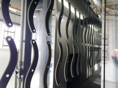 Toz kaplama hattı. Metal paneller, üstteki taşıma hattında askıya alındı. Elektrostatik alanda boyama ürünleri.