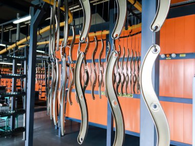 Toz kaplama hattı. Metal paneller, üstteki taşıma hattında askıya alındı. Elektrostatik alanda boyama ürünleri.