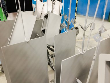Toz kaplama hattı. Metal paneller, üstteki taşıma hattında askıya alındı. Elektrostatik alanda boyama ürünleri.