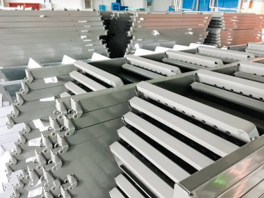 Toz kaplama hattı. Metal paneller, üstteki taşıma hattında askıya alındı. Elektrostatik alanda boyama ürünleri.