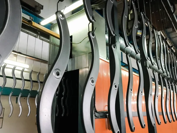 Toz kaplama hattı. Metal paneller, üstteki taşıma hattında askıya alındı. Elektrostatik alanda boyama ürünleri.