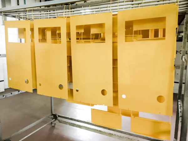 Toz kaplama hattı. Metal paneller, üstteki taşıma hattında askıya alındı. Elektrostatik alanda boyama ürünleri.