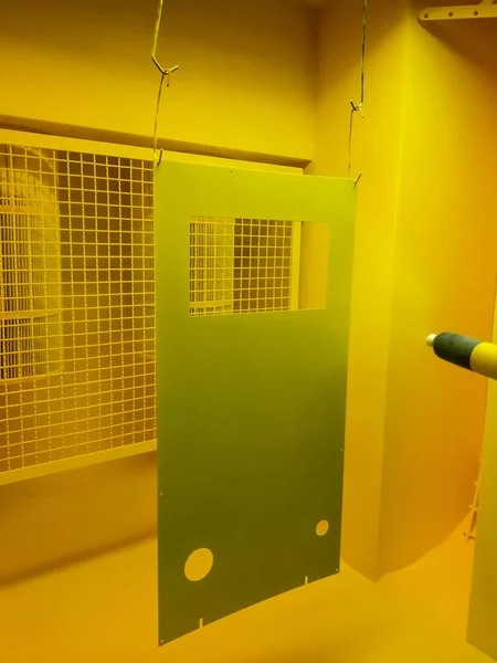 Toz kaplama hattı. Metal paneller, üstteki taşıma hattında askıya alındı. Elektrostatik alanda boyama ürünleri.