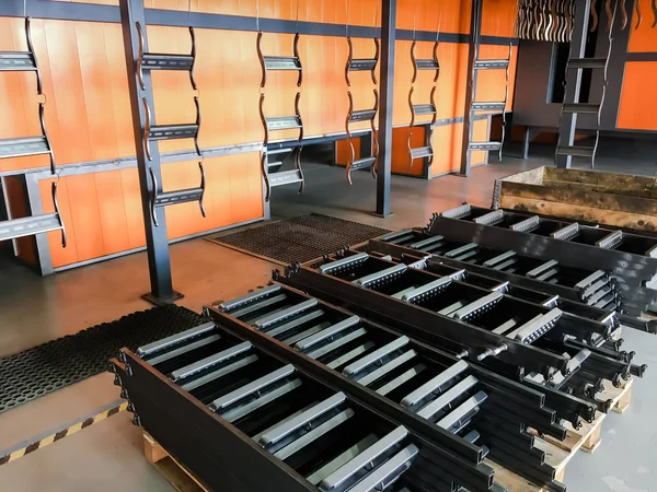 Toz kaplama hattı. Metal paneller, üstteki taşıma hattında askıya alındı. Elektrostatik alanda boyama ürünleri.