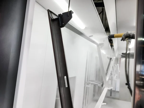 Toz kaplama hattı. Metal paneller, üstteki taşıma hattında askıya alındı. Elektrostatik alanda boyama ürünleri.