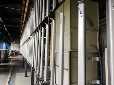 Toz kaplama hattı. Metal paneller, üstteki taşıma hattında askıya alındı. Elektrostatik alanda boyama ürünleri.