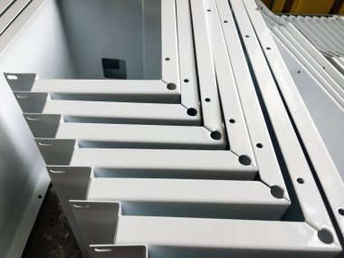 Toz kaplama hattı. Metal paneller, üstteki taşıma hattında askıya alındı. Elektrostatik alanda boyama ürünleri.