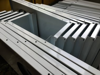 Toz kaplama hattı. Metal paneller, üstteki taşıma hattında askıya alındı. Elektrostatik alanda boyama ürünleri.