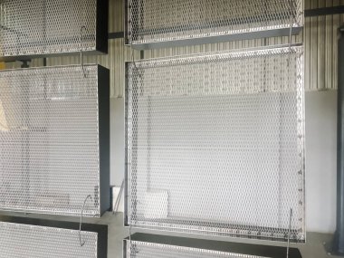 Toz kaplama hattı. Metal paneller, üstteki taşıma hattında askıya alındı. Elektrostatik alanda boyama ürünleri.