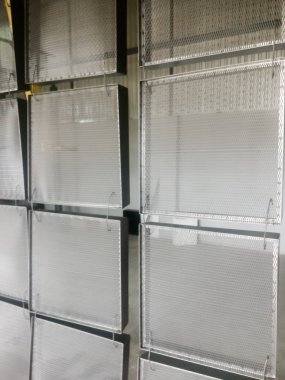 Toz kaplama hattı. Metal paneller, üstteki taşıma hattında askıya alındı. Elektrostatik alanda boyama ürünleri.