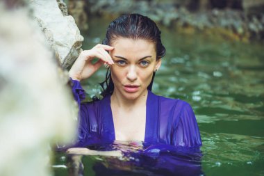 Tropik suda poz veren güzel bir kadın.