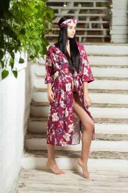 Tropiklerdeki bir tatil köyünde, açık renk elbiseli güzel bir kadın.