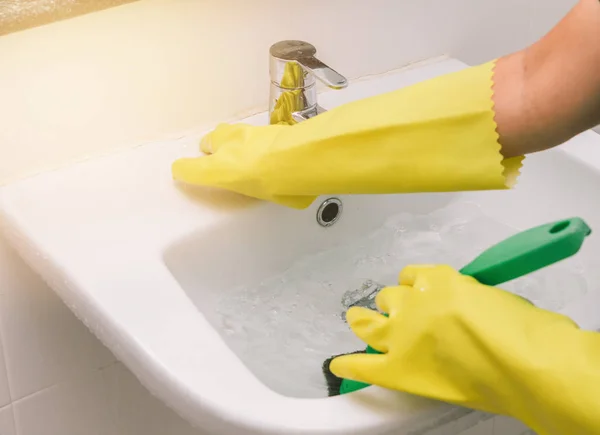 Housewife wearing yellow rubber glove and using brush cleaning b — Stock Photo, Image